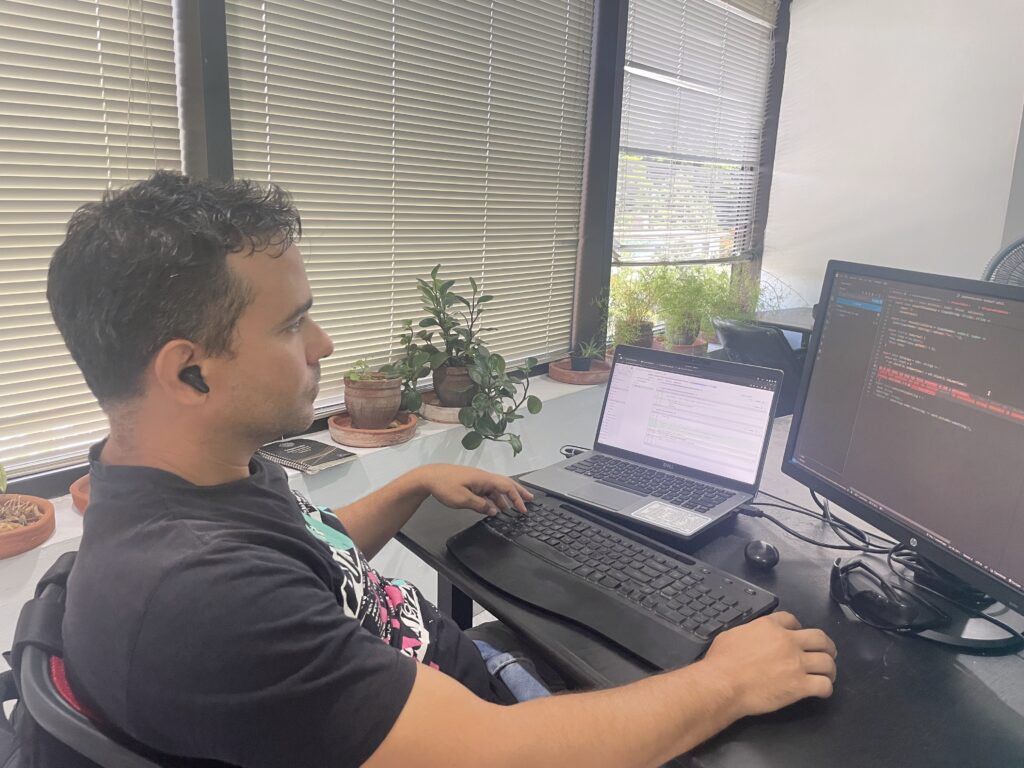 Joven latino centado frente a laptop en desarrollo web